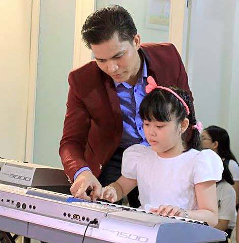 Thầy giáo hướng dẫn cho học sinh môn Đàn Organ tại lớp nhạc ChaChaCha
